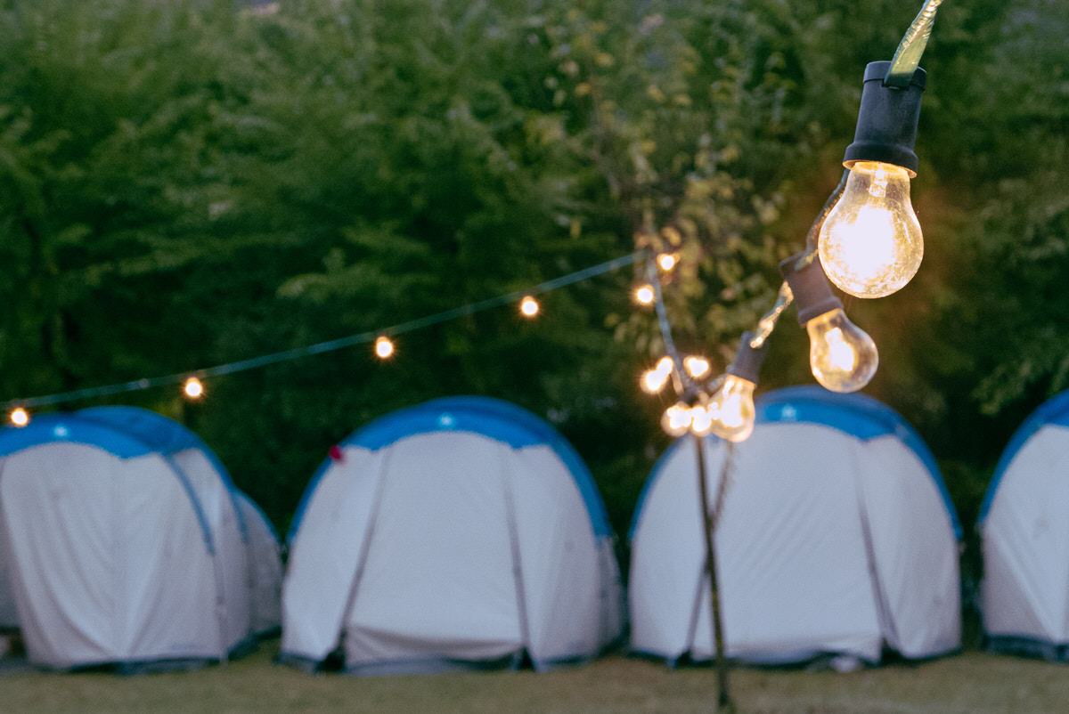 Group of camping tents with festoon lighting